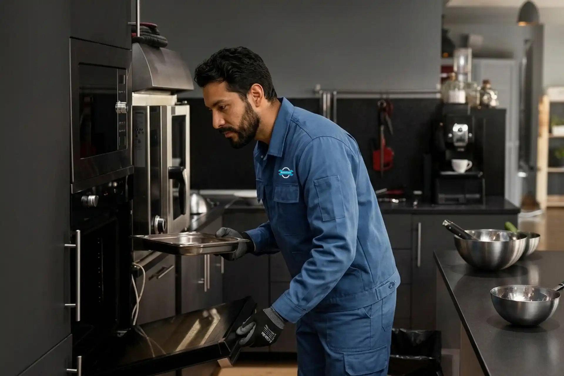 Técnico colombiano de ManteniCentro con uniforme azul realizando el mantenimiento preventivo de un horno de cocina industrial en un restaurante de Cartagena.